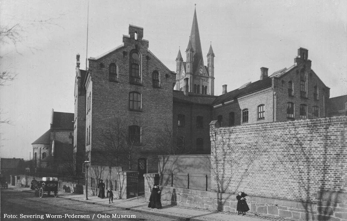 ELDST AV ALLE fotografier vi har funnet som først og fremst avbilder skolebygningen er dette. Her sett mot «gutteinngangen» i det som før hadde hett Langbakken, men trolig som direkte følge av byggeprosjektet ble hetende Borggata (endret 1866). Bildet er tatt på 1890-tallet. Barna på bildet fikk trolig sin første undervisning her.